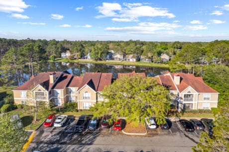 Spacious apartment complex near Tampa with pond and lush greenery, ideal for residential living.