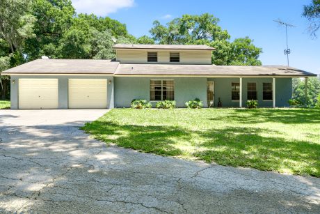 Modern suburban house with a spacious front yard and two-car garage.