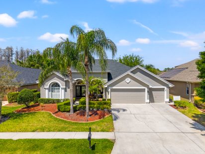 Modern suburban house with lush landscaping and palm trees in Tampa, Florida.