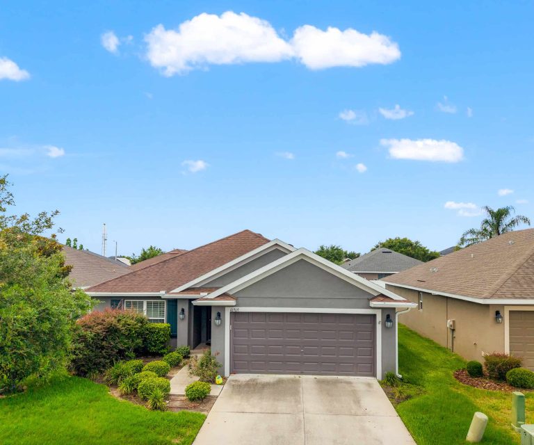 Bright modern single-family home in Tampa, Florida with a well-manicured lawn and charming landscaping.