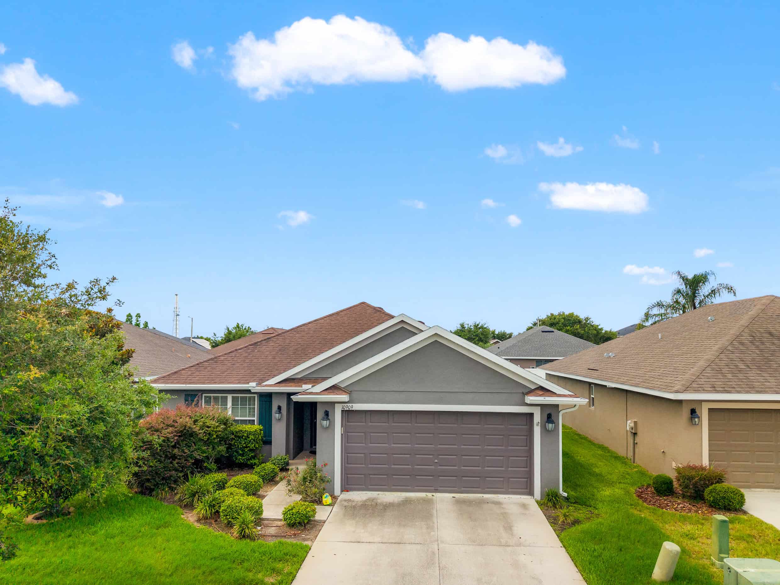 Bright modern single-family home in Tampa, Florida with a well-manicured lawn and charming landscaping.