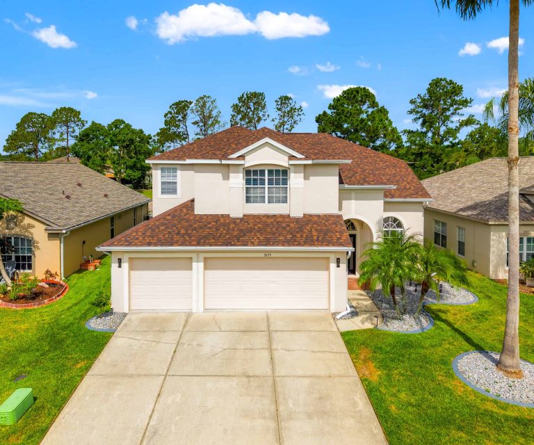 Spacious modern house with a well-manicured lawn and tropical landscaping in Tampa, Florida.