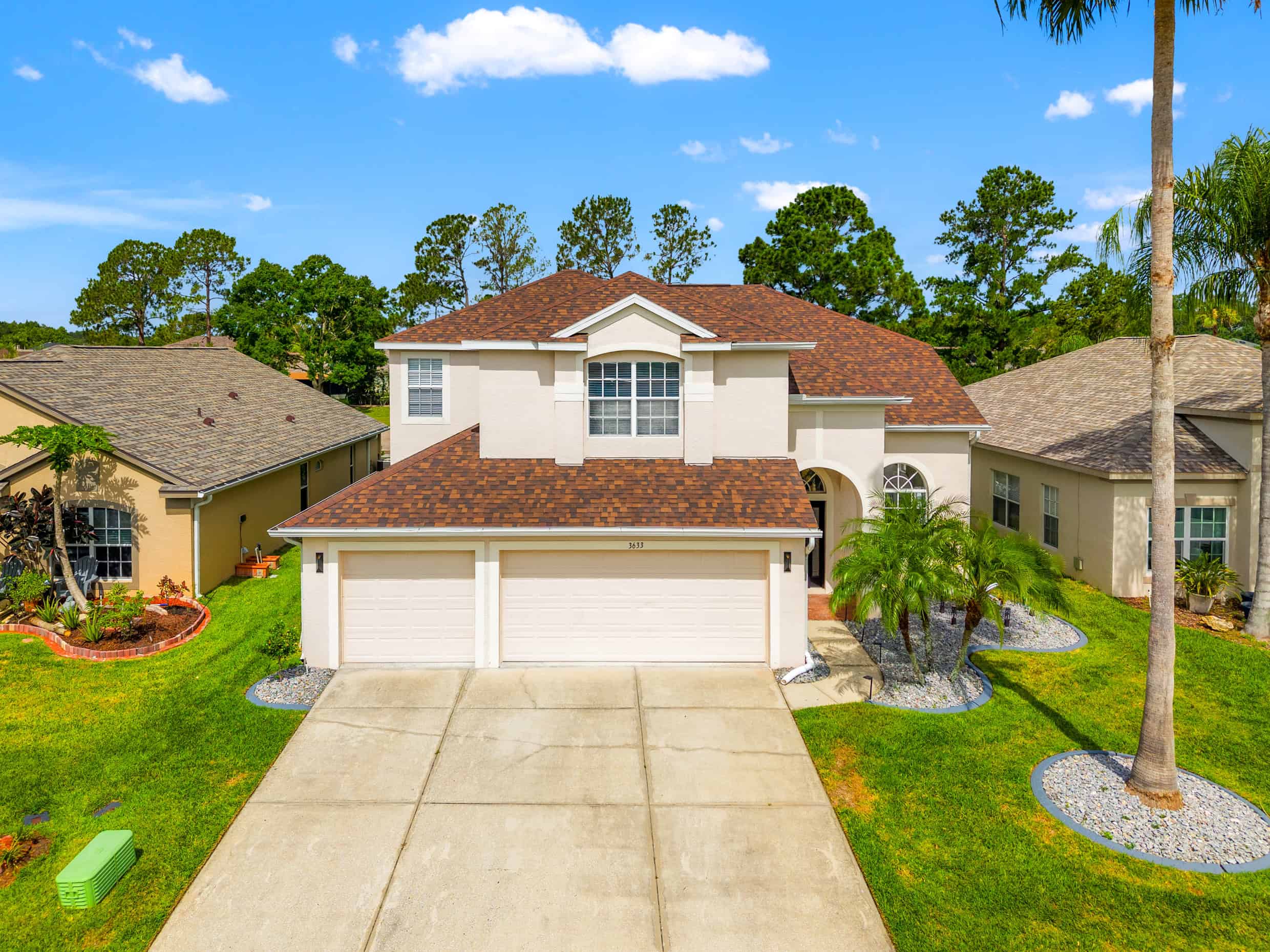Spacious modern house with a well-manicured lawn and tropical landscaping in Tampa, Florida.