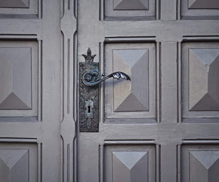 Beautifully crafted vintage iron door handle on a classic wooden garage door.